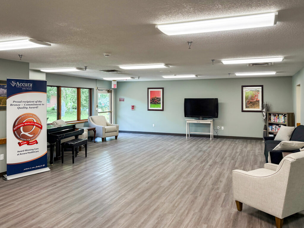 Common area at Accura HealthCare of New Hampton with seating, piano and television