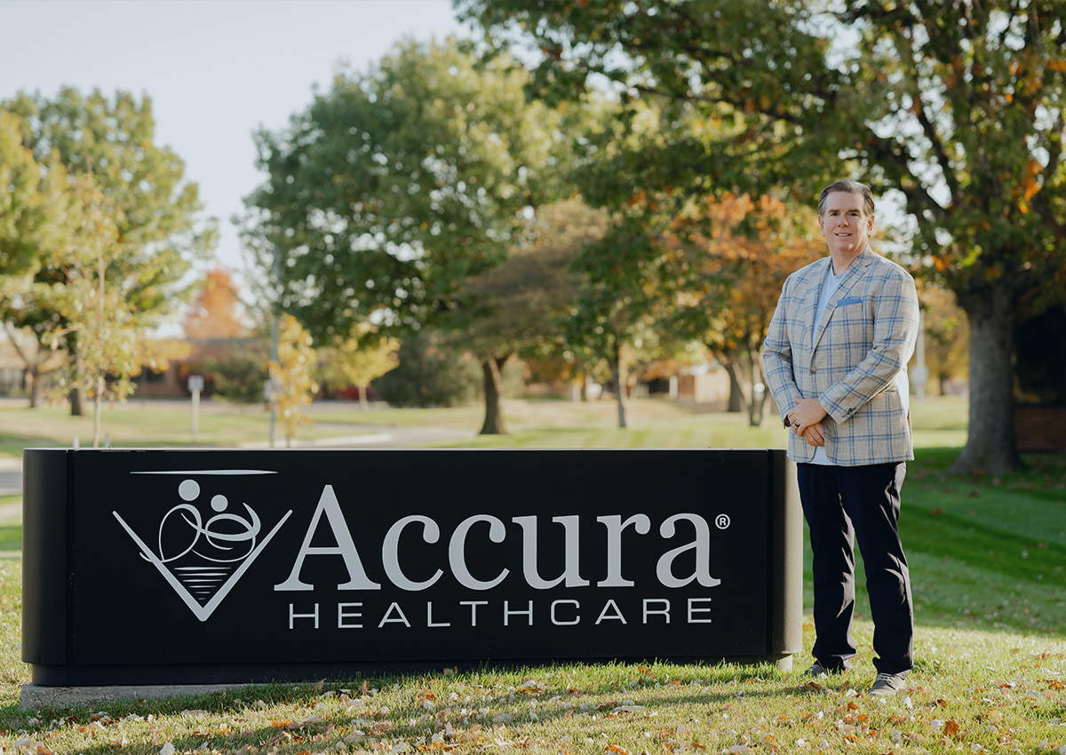 Accura HealthCare Founder and CEO Ted LeNeave standing beside the Accura HealthCare sign.